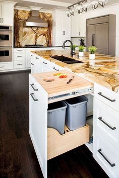 a kitchen with white cabinets and wooden counter tops