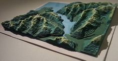 a piece of paper that has been cut out to look like a mountain range with trees on it