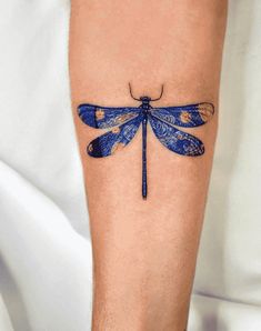 a blue dragonfly tattoo on the leg