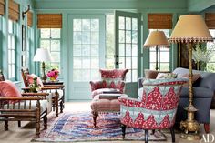 a living room filled with lots of furniture and decor on top of carpeted flooring