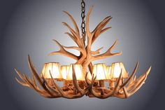 a chandelier made out of antlers with lamps hanging from the middle one