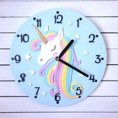 a blue clock with a unicorn face on it's face and numbers painted on the sides