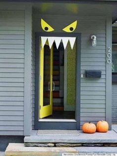 two pumpkins sitting on the front porch of a house with monster's teeth painted on it