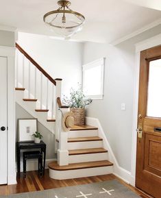 there is a basket on the stairs next to the door and a rug in front of it