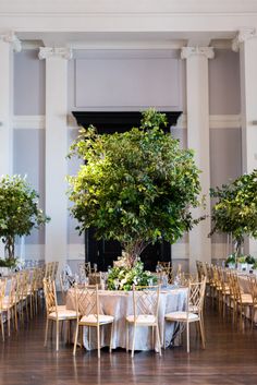 the tables are set up with white linens and gold chairs for an elegant wedding reception