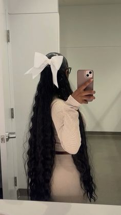 a woman taking a selfie in front of a mirror with her long black hair