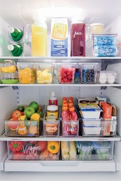 an open refrigerator filled with lots of different types of drinks and food in plastic containers