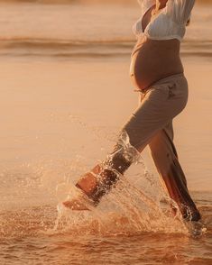 a pregnant woman is walking in the water