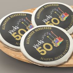 three black and gold 50th birthday coasters on a wooden platter with the number 50