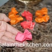 a person is peeling orange and pink bows on a counter