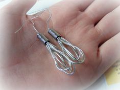 a hand holding two silver wires in it's palm