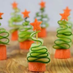 there are many small christmas trees made out of cucumber and carrot sticks on the table