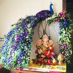 there is an elephant statue on the table with flowers and other decorations around it,