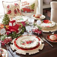 a table set for christmas with plates and place settings