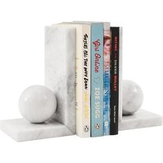 three books are stacked on top of each other in front of a marble bookend