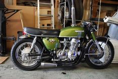 a green motorcycle is parked in a garage