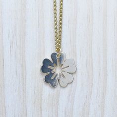 This necklace is made from a flower coin charm. The charm is gold plated and has a very shiny surface. The necklace is finished off with a gold plated stainless steel chain. You can choose the style and length of the chain. Please choose the length you would like the necklace in. Please choose the chain style you would like your pendant on. Please note that all necklaces are handmade and may differ from the pictured. The picture shows multiple necklaces. You will receive one necklace with one pe Gold Flower Charm Pendant Necklace, Gold Pendant Flower Necklace With Flower Charm, Gold Pendant Necklace With Flower Charm, Yellow Gold Flower Charm Necklaces, Brass Pendant Necklace With Flower Charm, Gold Brass Necklace With Flower Charm, Yellow Gold Flower Necklaces With Charms, Gold Nickel-free Flower Pendant Necklace, Gold Necklace With Flower Charm In Brass