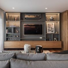 a living room with couches and a large television on the entertainment center in it