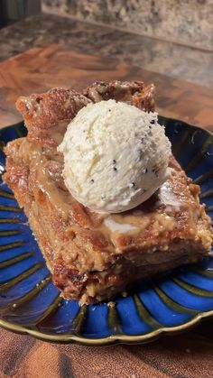 a piece of pie with ice cream on top sits on a blue and gold plate