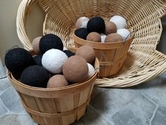 two baskets filled with black and white balls on top of a stone floor next to a wicker basket