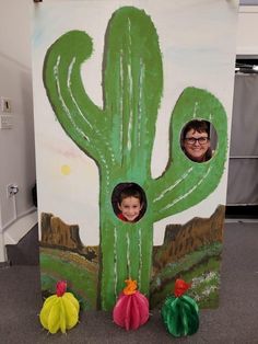 a cardboard cactus with two children's faces in it