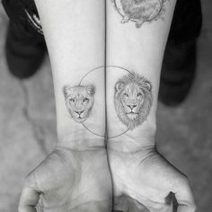 two people holding hands with tattoos on their wrists and one has a lion, the other is a dog