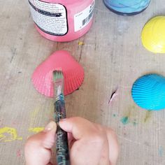 a person is painting some paper plates with paint