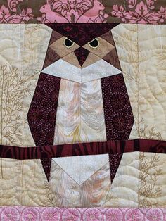 an owl is sitting on top of a quilt