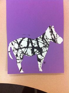 a dog made out of black and white paper on a purple background