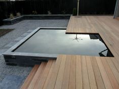 a wooden deck with a pond in the middle