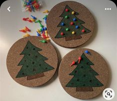 three cork coasters decorated with christmas trees