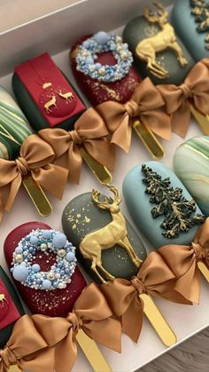 a box filled with lots of different types of decorated cake on top of wooden sticks