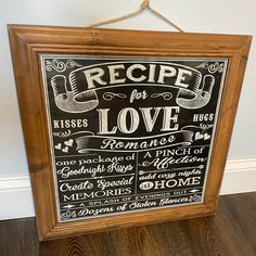 a chalkboard sign hanging on the wall in front of a wooden frame that says recipe for love