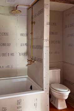 an unfinished bathroom with a tub, toilet and shower in the wall that is being built