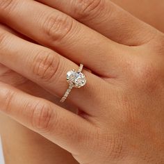 a woman's hand with a diamond ring on top of her finger and an engagement band