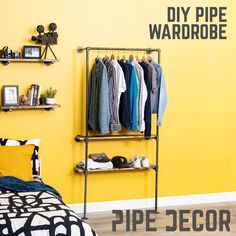 a clothes rack in front of a yellow wall with the words diy pipe wardrobe on it