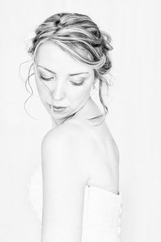 a black and white photo of a woman with her eyes closed wearing a strapless dress