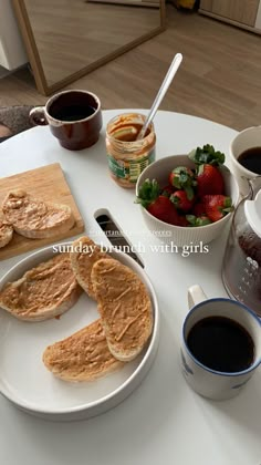 a white table topped with plates of food and cups of coffee