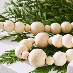 mushrooms are arranged on a white surface next to some green leaves and pine needles in the background