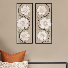 two metal wall art pieces with white flowers on them