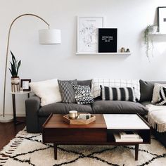 a living room with a couch, coffee table and pictures on the wall above it