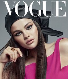 a woman with long hair wearing a black hat and pink dress on the cover of a magazine