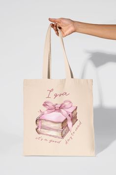 Iqra It's a Good Day to Read 100% Cotton Tote Bag with Pink Book Stack and Bow Carry your essentials in style with our charming 100% Cotton Tote Bag, featuring a whimsical design of a stack of pink books adorned with a delicate bow on top with the quote "Iqra it's the perfect day to read". This delightful tote is the perfect practical accessory for book lovers and fashionistas alike. Key Features: Adorable Design: The eye-catching stack of pink books with a bow adds a playful and feminine touch Pink Bags For Back To School Gift, Bookish Bags With Letter Print For Gift, Pink Book, Bow Coquette, It's A Good Day, Pink Books, Eid Gift, Book Stack, Whimsical Design