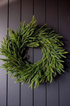 a green wreath hanging on the side of a wall