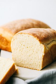 two loaves of bread sitting next to each other on a white surface with a blue towel