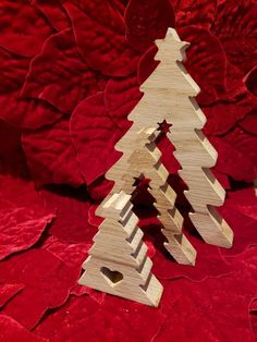 a wooden christmas tree sitting on top of a red cloth