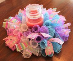 a close up of a bunch of hair bows on a table with a bottle in the middle