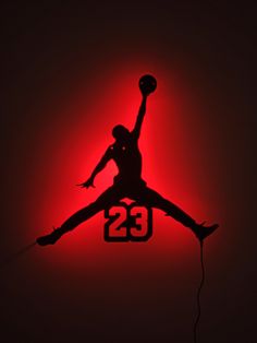 the silhouette of a basketball player jumping up into the air with his arms in the air