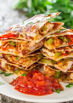 several quesadillas stacked on top of each other with salsa in the background