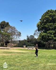 a person standing in the grass flying a kite